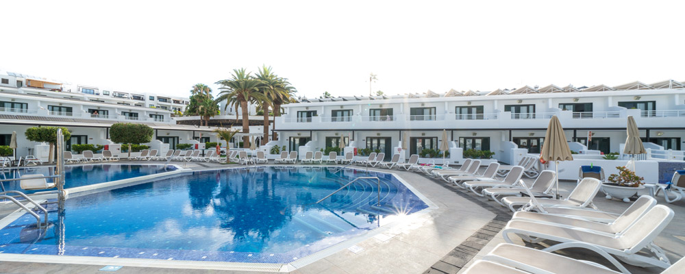 Pool and lounge chairs at Relaxia Lanzaplaya hotel